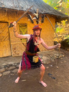 Me, dressed in traditional costume, with a sword in one hand and a bow in the other.