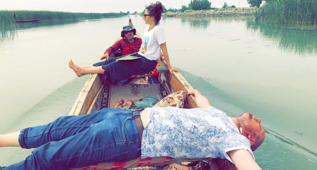 Me lying across a boat in the Mesopotamian marshes with Anna in the background.