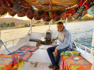 The young skipper smiles broadly on the colourful boat back across the Nile.