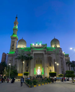 The Abu al-Abbas al-Mursi Mosque at night, lit up with green lights.